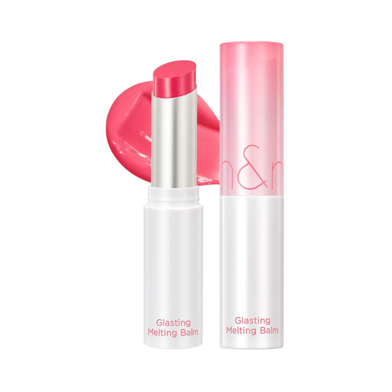 Rom&nd Glasting Melting Balm i Lovely Pink med hvidt rør og pink hætte. Pink farvesmøre bagved.