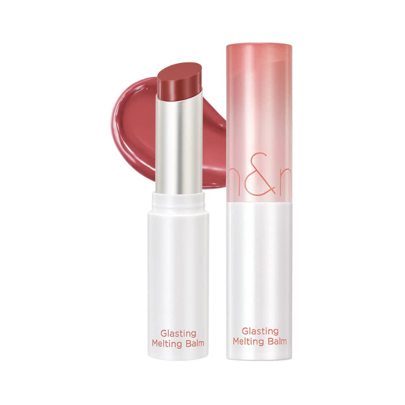 Lip balm i rosa nuance, udtrukket fra hvidt rør med rød tekst. Stribe af farve bagved.