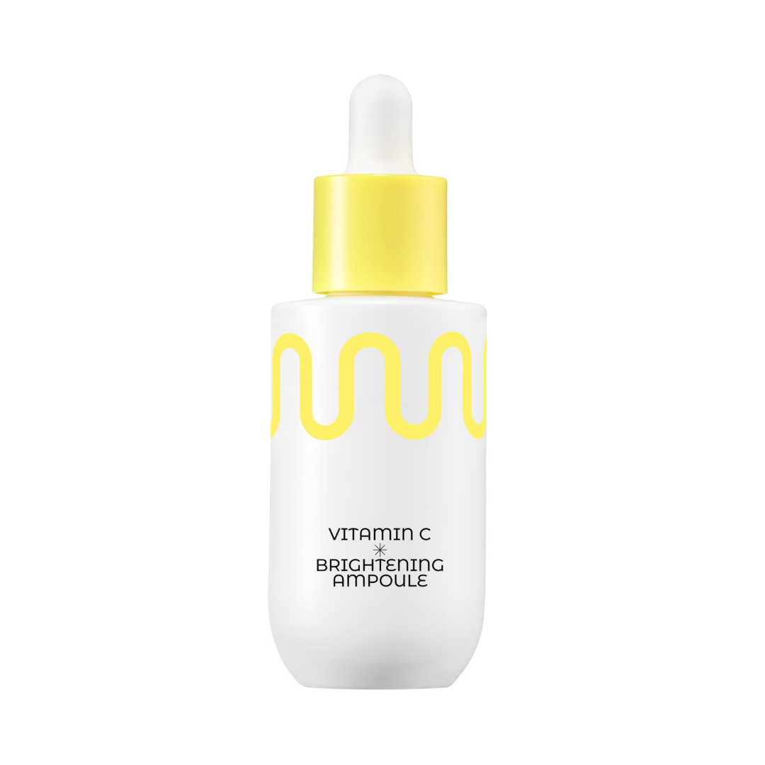 Hvid flaske med gul bølge og pipette, teksten "Vitamin C Brightening Ampoule."
