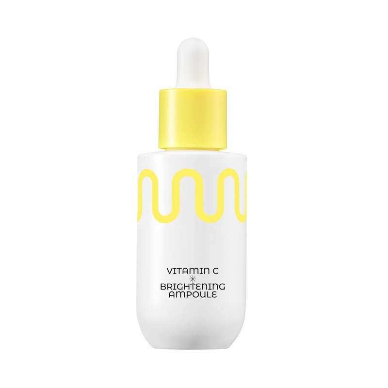 Hvid flaske med gul bølge og pipette, teksten "Vitamin C Brightening Ampoule."