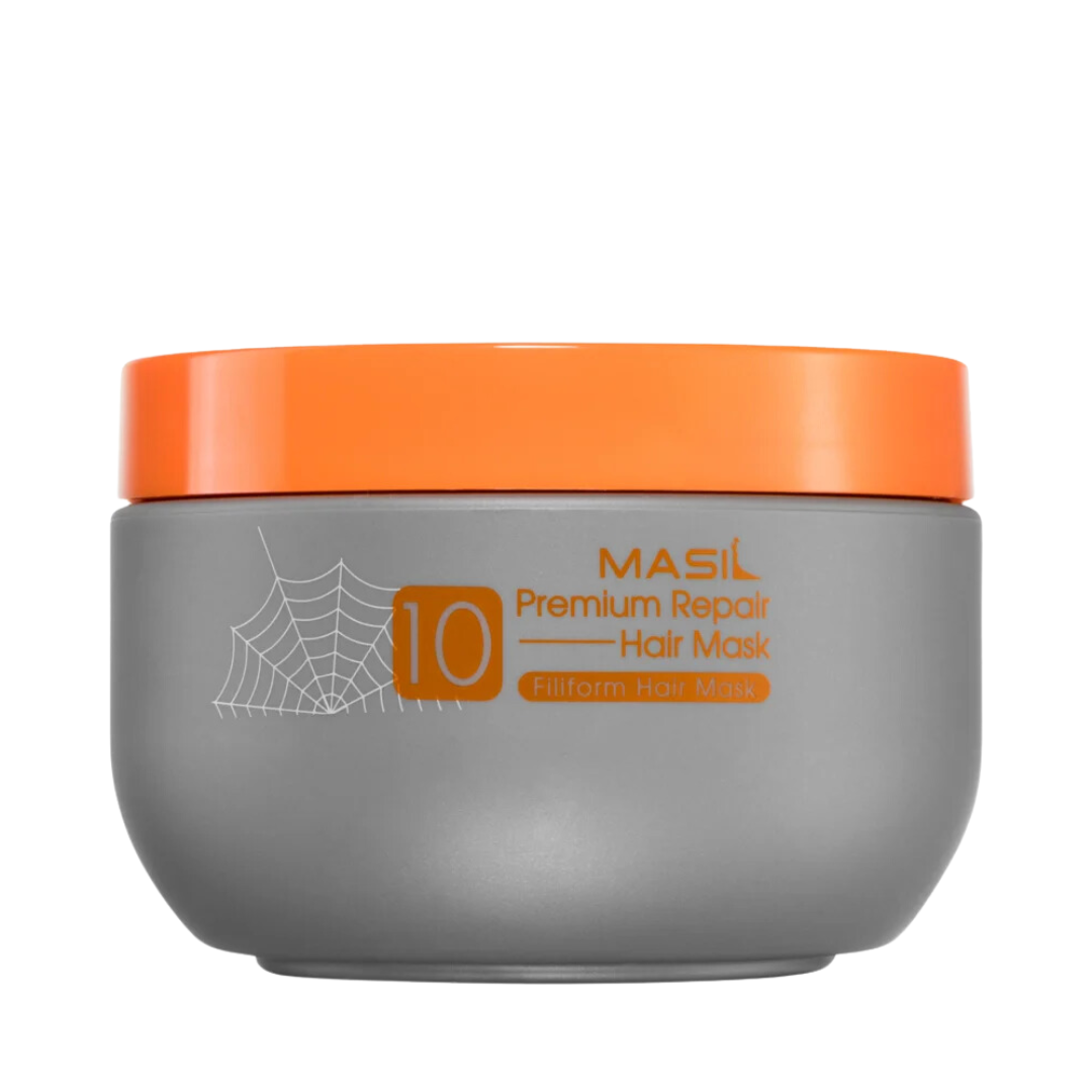 Grå beholder med orange låg, edderkoppespind-design og teksten "Masil 10 Premium Repair Hair Mask".