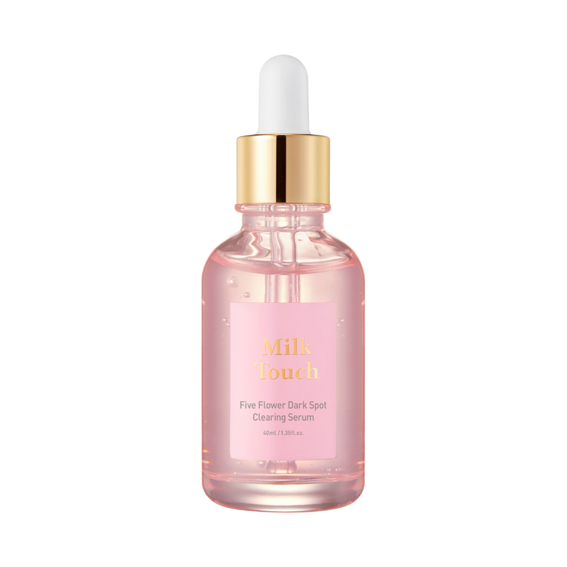 Klar pink flaske med guldhætte og hvid pipette, mærket "Milk Touch - Five Flower Dark Spot Clearing Serum".