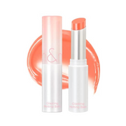 Rom&nd Glasting Melting Balm i hvidt hylster med koralfarve og svag skrift foran koralfarveprøve.