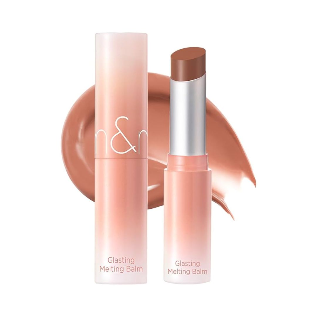 Rom&nd Glasting Melting Balm i koralfarve, slankt rør med farveprøve i baggrunden.