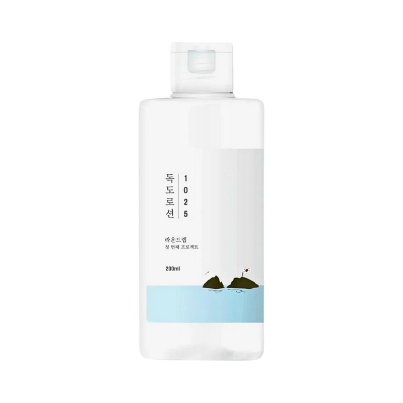Rundt, gennemsigtigt flaske med hvidt label, koreansk tekst og illustration af øer og hav.