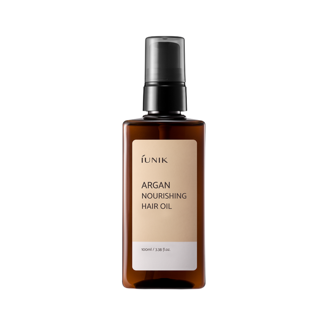 Brun flaske med pumpe, mærket "iUNIK Argan Nourishing Hair Oil," 100 ml.