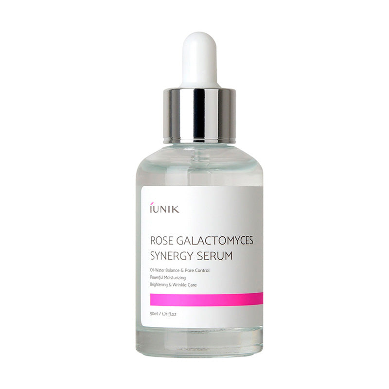 Klar flaske med pipette, hvidt label med tekst: "Rose Galactomyces Synergy Serum", pink detalje.