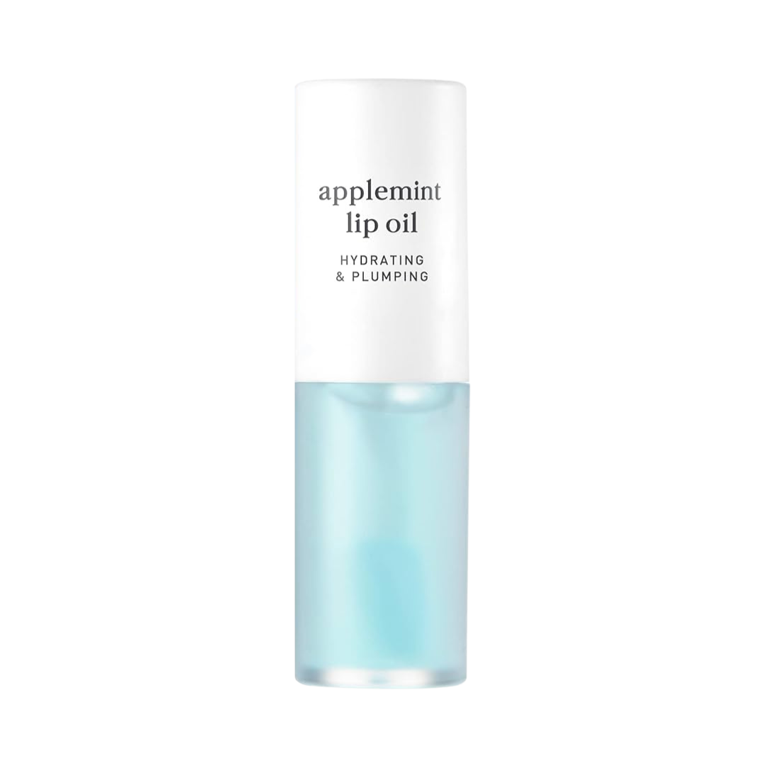 Klar flaske med blå lipolie, hvid hætte. Tekst: "applemint lip oil", "hydrating & plumping".