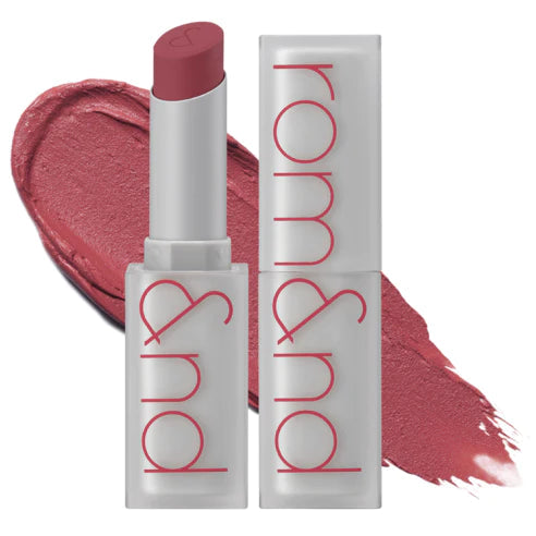 Rom&nd Zero Matte Lipstick i støvet pink. Hvid emballage med rød tekst, farveprøve i baggrunden.