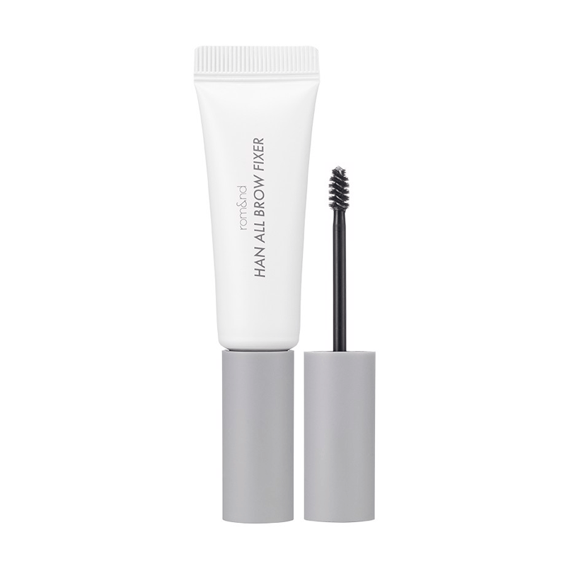 Hvid tube med "Rom&nd Han All Brow Fixer", grå hætte, sort brynbørste ved siden af.
