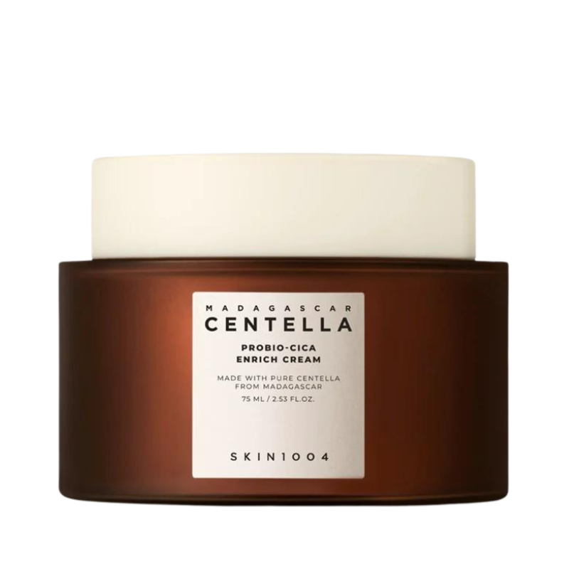 Brun krukke med hvidt låg og label: "Madagascar Centella Probio-Cica Enrich Cream" fra SKIN1004.