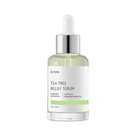 Flaske med dråbe, lysegrønt serum, mærket "iUNIK Tea Tree Relief Serum" med plejeegenskaber.