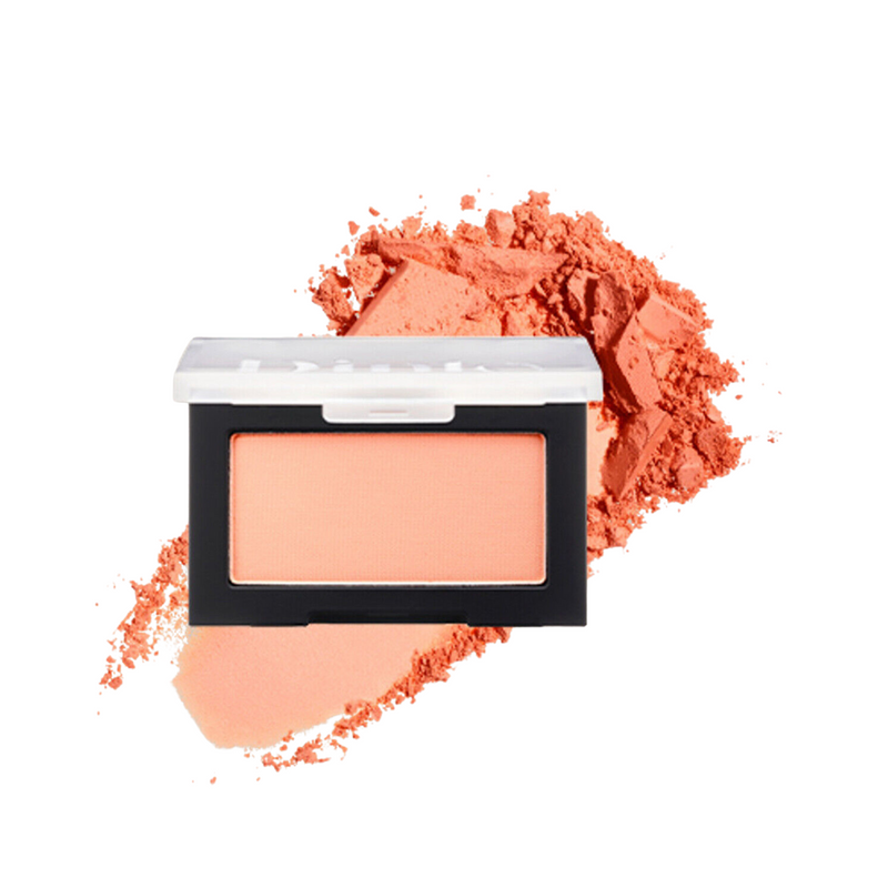 Peachfarvet blusher i sort etui, spredt pulver bagved.