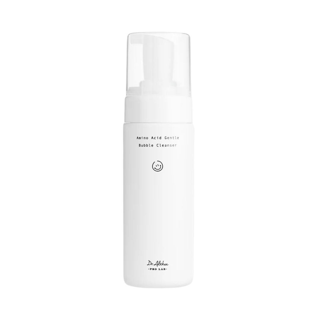 Hvid flaske med teksten "Amino Acid Gentle Bubble Cleanser" og en smiley-ikon.