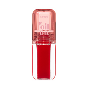 Klar flaske med rød læbeolie, lyserød hætte med mærket "Etude" og "oil tint" tekst.