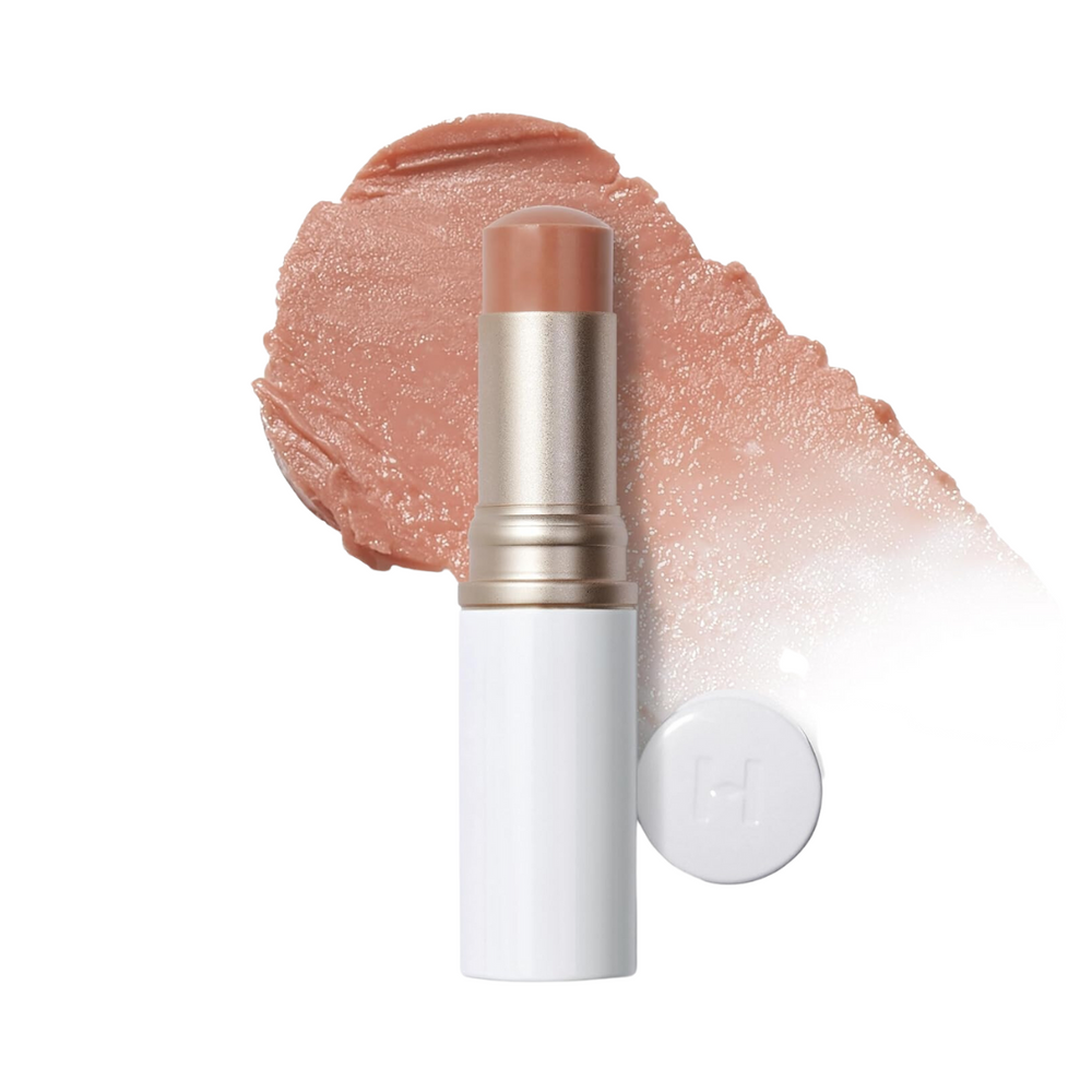 Beige balsamstift med hvid hætte og farvesmear.
