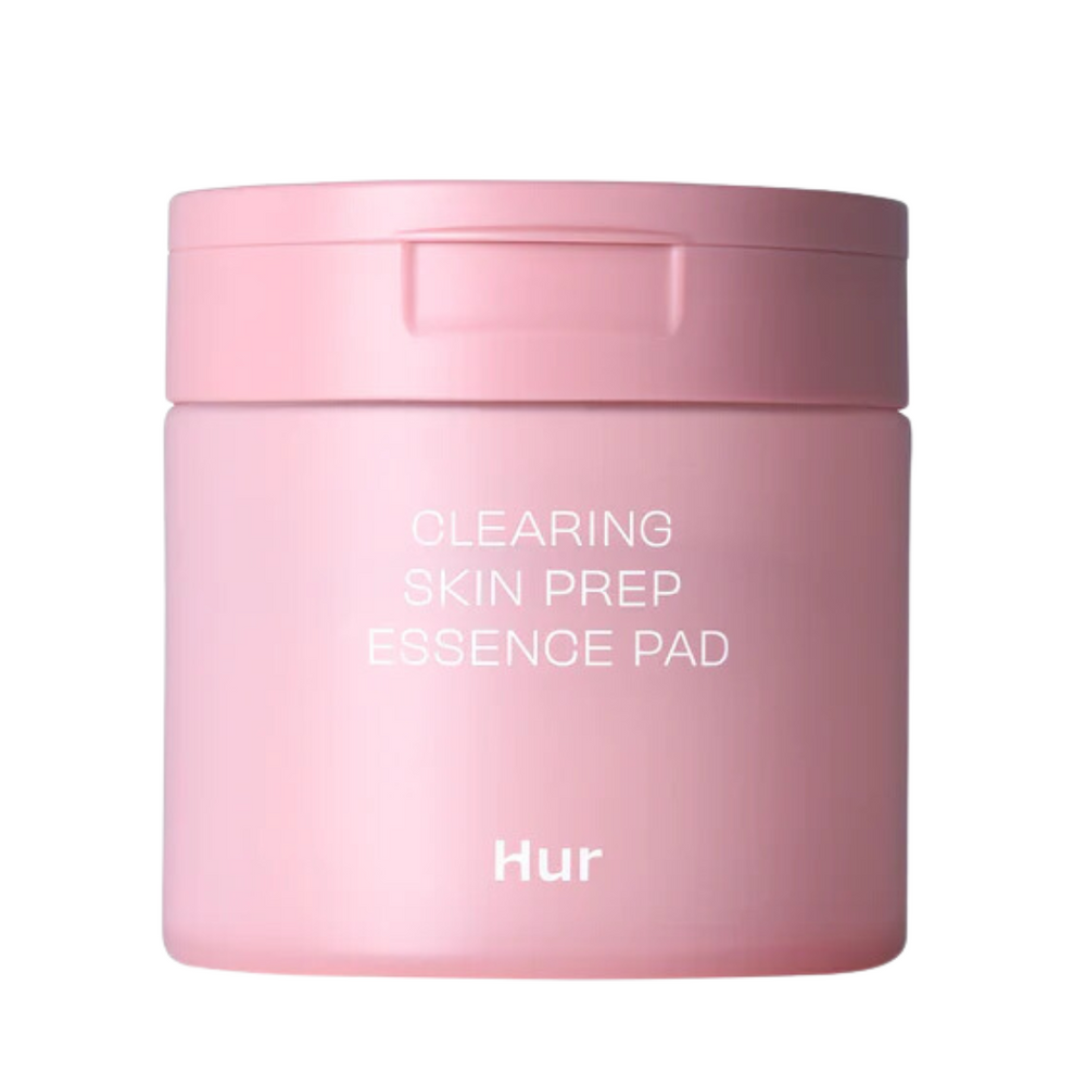 Lyserød, cylindrisk beholder med teksten "CLEARING SKIN PREP ESSENCE PAD" og "Hur" på forsiden.