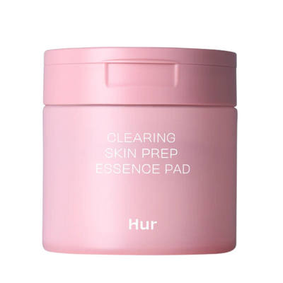 Lyserød, cylindrisk beholder med teksten "CLEARING SKIN PREP ESSENCE PAD" og "Hur" på forsiden.