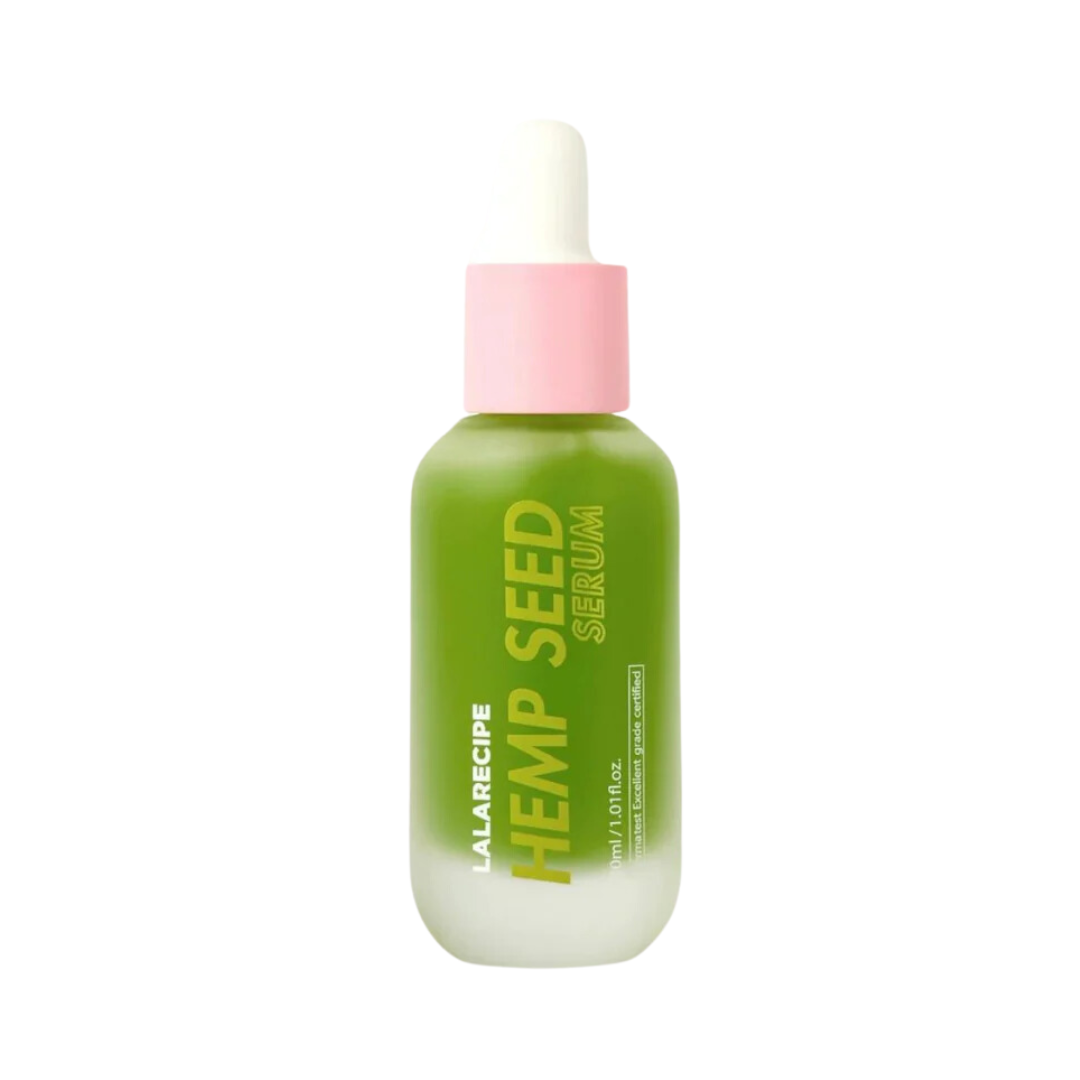 Grøn flaske med pink pipettehætte, teksten "Lala Recipe Hemp Seed Serum" er synlig.