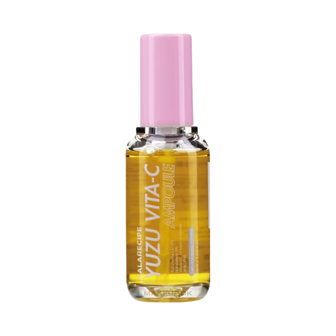 Klar flaske med gul væske og lyserød hætte. Etiket: "YUZU VITA-C AMPOULE" i hvid tekst.