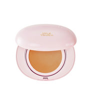 Lyserød kompakt med beige pude og "Milk Touch" i guld på låget.