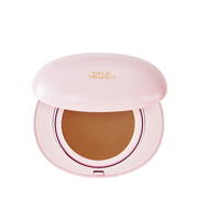 Lyserød kompakt med "Milk Touch" logo. Indeni ses en kanelbrun cushion foundation.