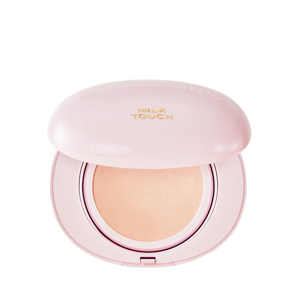 Lys pink kompakt med åben låg, viser en rosafarvet pudder; "Milk Touch" i guld på låget.