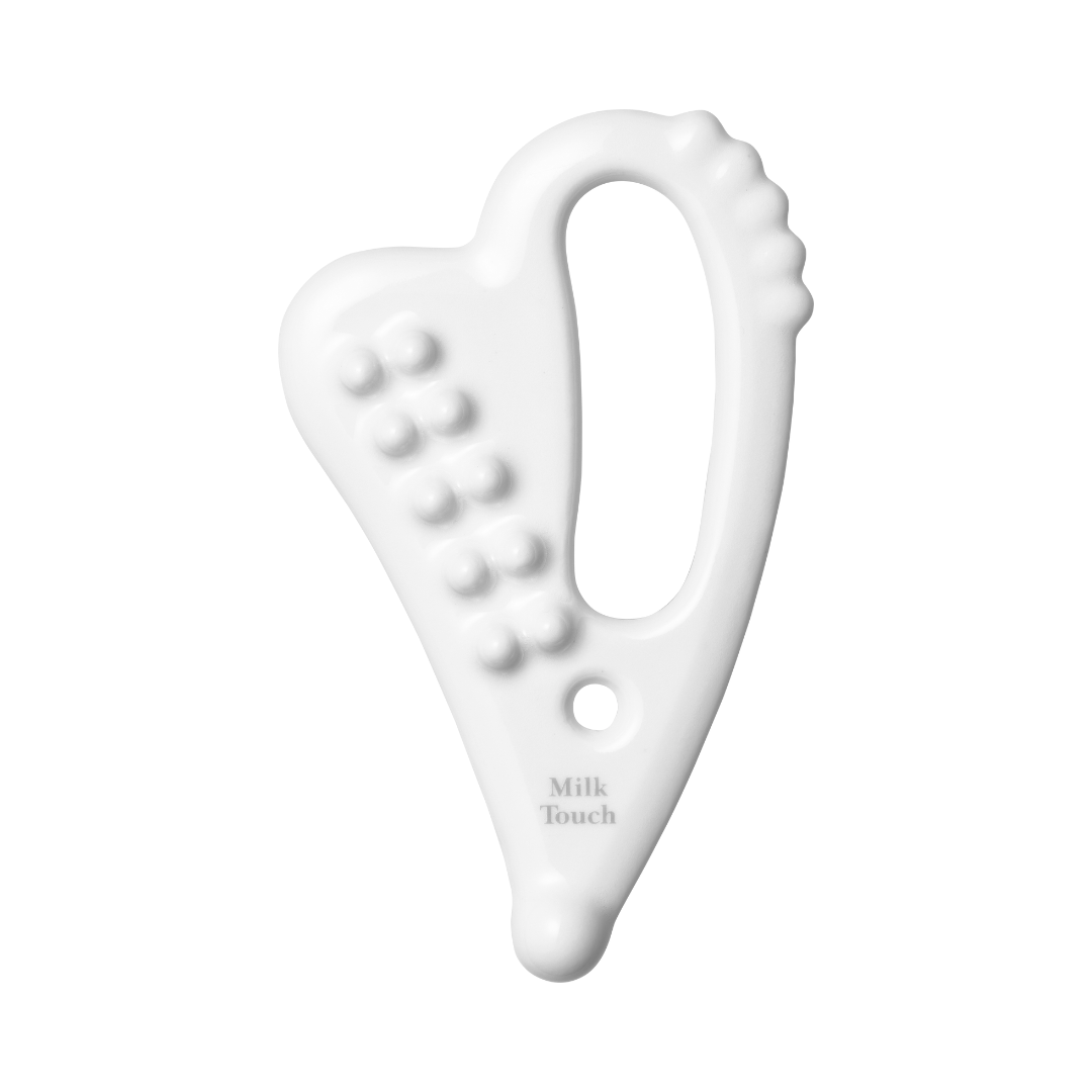 Hvid, hjerteformet keramisk gua sha med knopper og hul, mærket "Milk Touch".