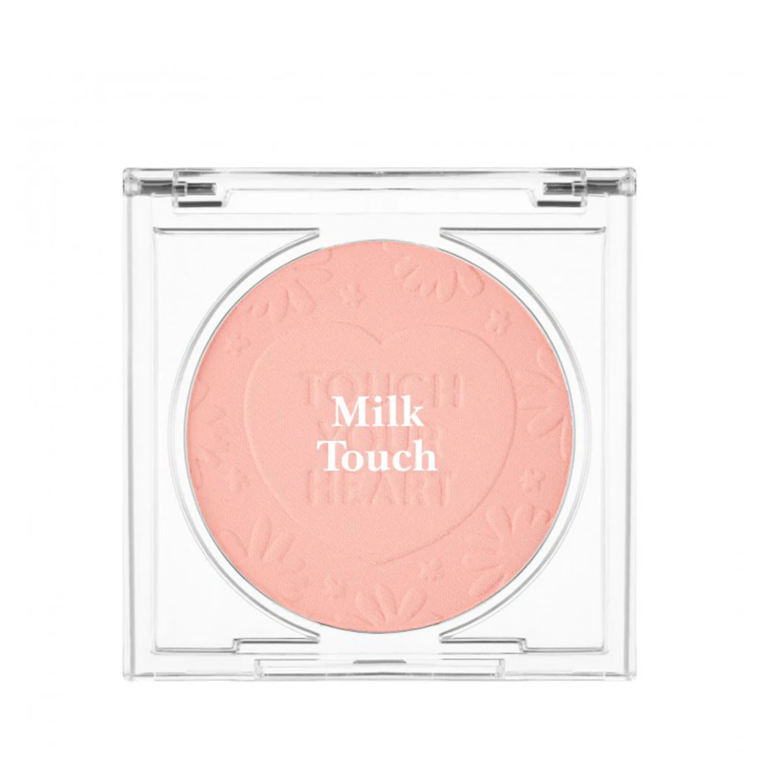 Blush i ferskenfarve med teksten "Milk Touch" præget på overfladen i et gennemsigtigt etui.