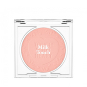 Blush i ferskenfarve med teksten "Milk Touch" præget på overfladen i et gennemsigtigt etui.