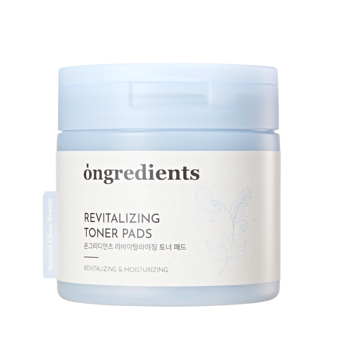 Lys blå beholder med "Ongredients Revitalizing Toner Pads" og blomsterdekoration.