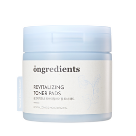 Lys blå beholder med "Ongredients Revitalizing Toner Pads" og blomsterdekoration.