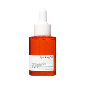 Orange glasflaske med hvid pipette. Etiket med teksten "Pyunkang Yul Brightening Care Serum".