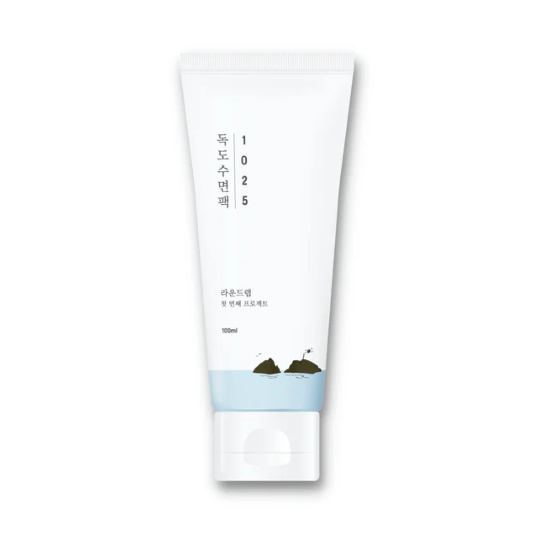 Hvid tube med teksten "1025 Dokdo Sleeping Pack" og koreansk skrift, minimalistisk design.