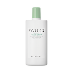 Hvid flaske med grøn låg, mærket "Madagascar Centella Tea-Trica Soothing Sun Milk".