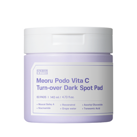Krukke med hvidt låg og lilla etiket. Tekst: Meoru Podo Vita C Turn-over Dark Spot Pad, ingredienser.