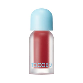 Lille flaske med rød lip oil, frostet glas, lyseblå låg, "TOCOBO" i blå skrift.
