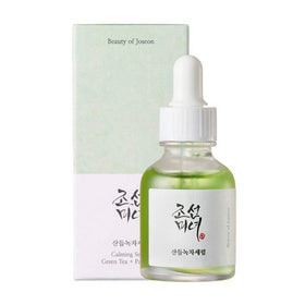 Flaske med grønt serum og pipette ved siden af en æske med koreansk tekst og produktnavn.