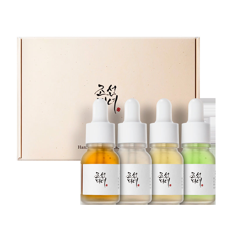 Beige æske med koreansk skrift og fire farvede flasker med pipette: gul, gennemsigtig, beige, grøn.