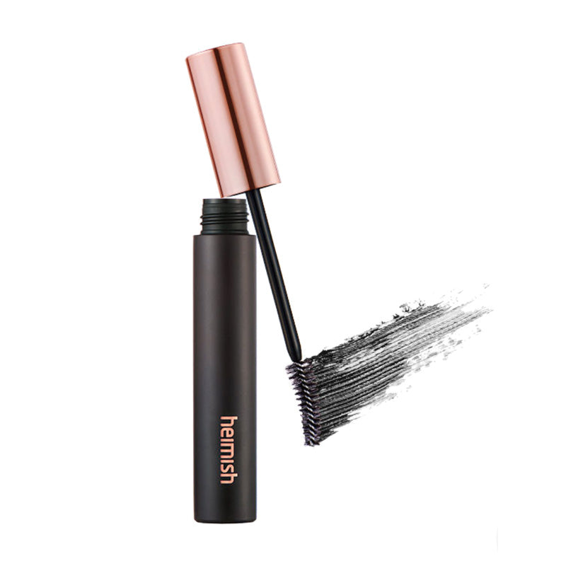 Sort mascara med børste og kobberlåg, mærket "heimish". Sort strøg viser påføring.