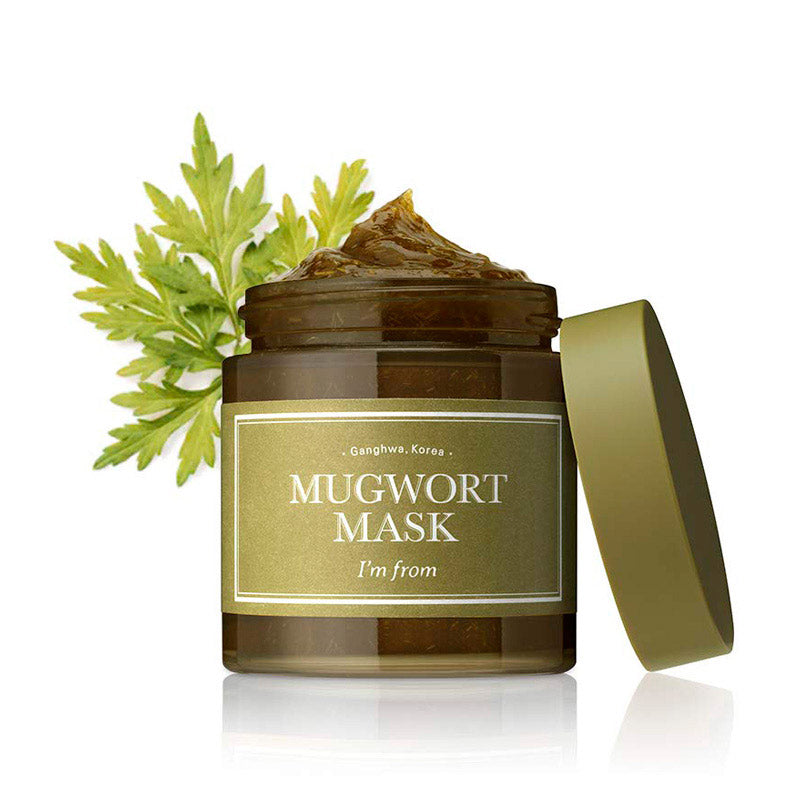Grøn krukke med Mugwort Mask, åben med grønt indhold. Mugwort blad bagved.