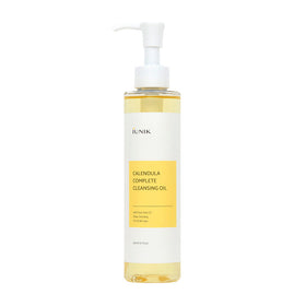 Klar flaske med hvid pumpe og gul væske. Etiket: "iUNIK Calendula Complete Cleansing Oil".