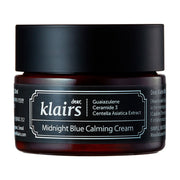 Mørk krukke med sort låg, etikette viser "klairs" og "Midnight Blue Calming Cream."