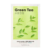 Pakke med grøn te arkmaske, grønne blade på lys baggrund, teksten "Green Tea" og "Missha".