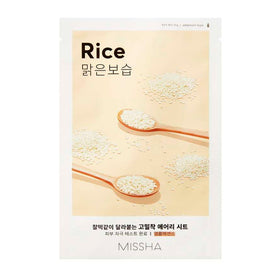 Missha Airy Fit Sheet Mask-pakke med ris, træskeer og ris på lys baggrund.