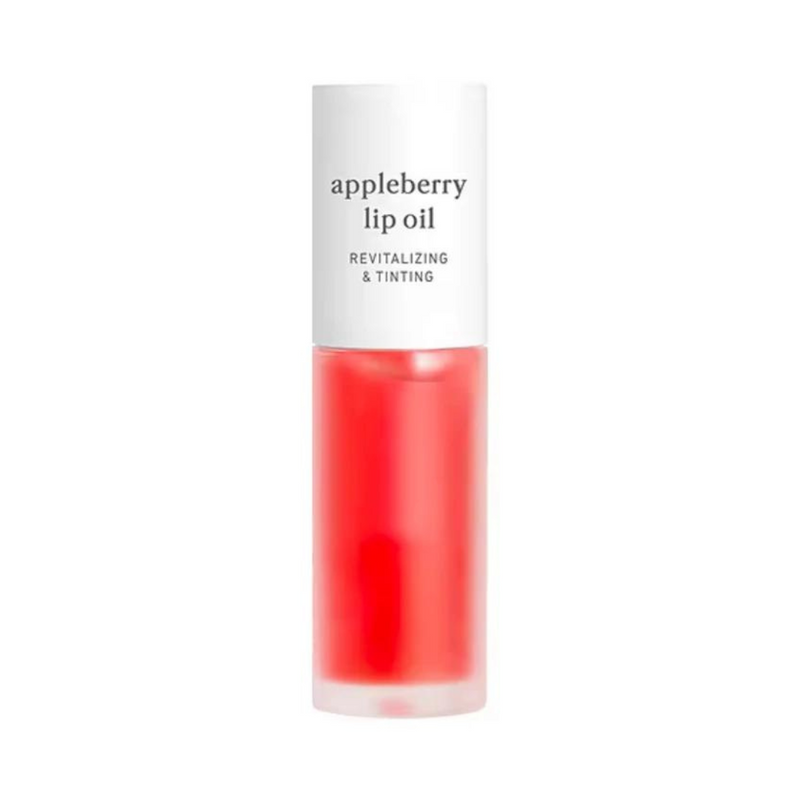 Klar flaske med hvidt låg, rød væske indeni. Tekst: "appleberry lip oil, revitalizing & tinting".