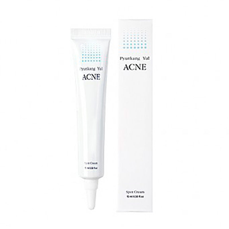 Hvid tube og æske med Pyunkang Yul Acne Spot Cream, blå prikker, sort tekst.