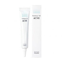 Hvid tube og æske med Pyunkang Yul Acne Spot Cream, blå prikker, sort tekst.
