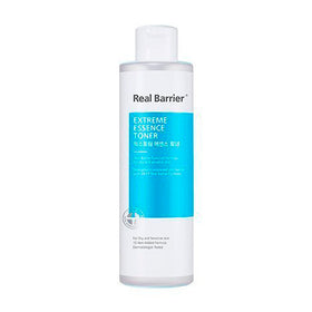 Hvid flaske med blå etiket. Tekst: "Real Barrier Extreme Essence Toner." Til tør og sensitiv hud.