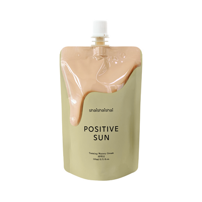 Beige pose med peach-farvet creme, teksten "shaishaishai Positive Sun, Tanning Watery Cream SPF22".